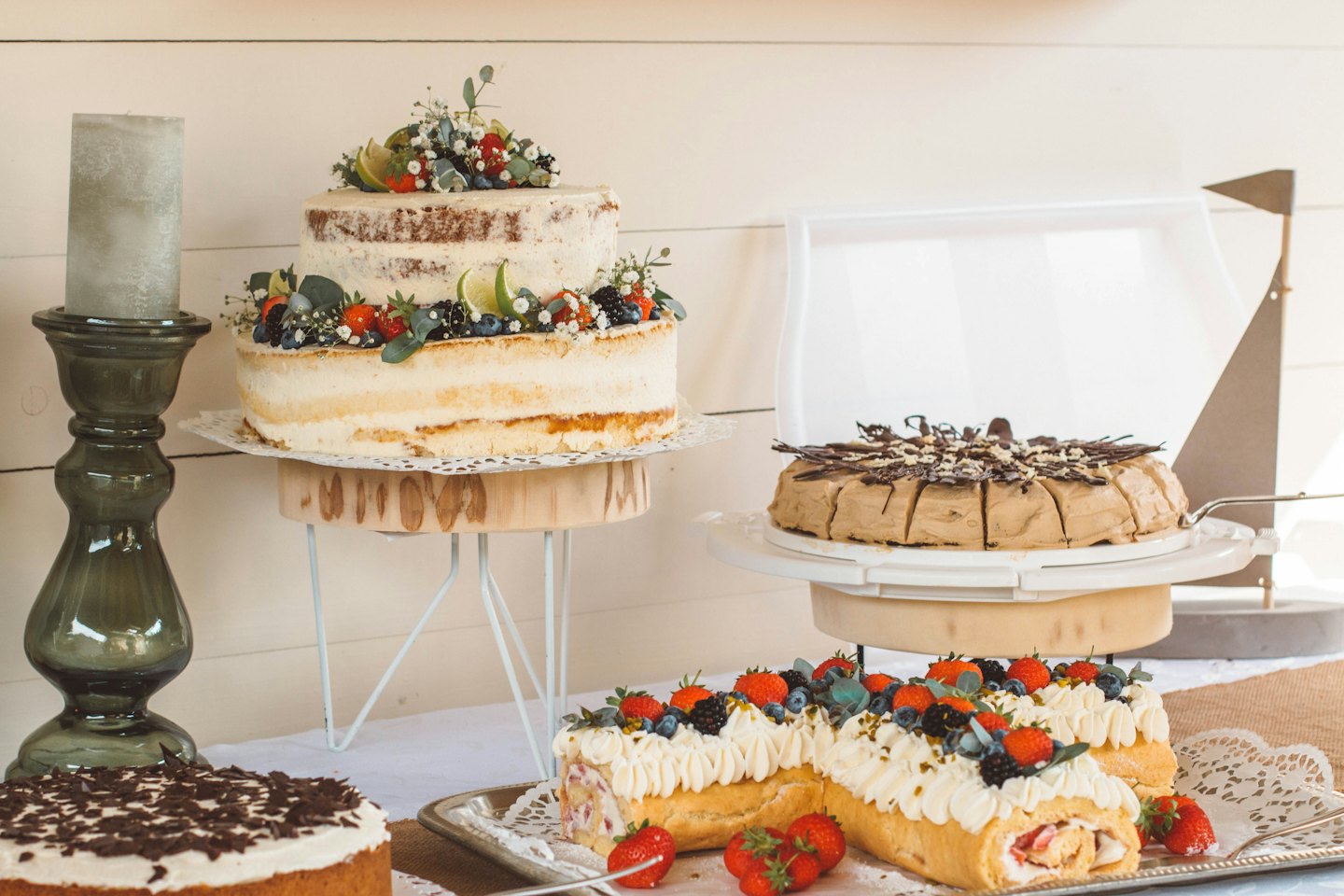 Assortment of beautiful cakes and pastries on a rustic table.